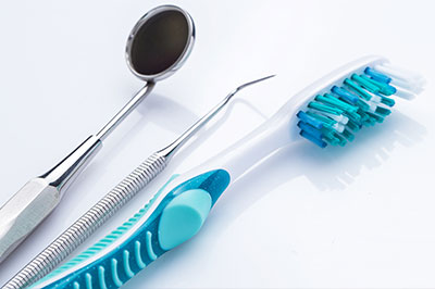 An image displaying dental tools, including a toothbrush with bristles, on a white background.
