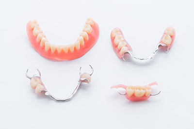 The image shows a collection of dental braces with red teeth, displayed on a white background.
