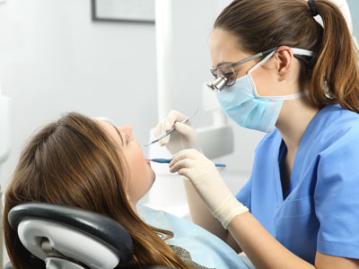 A dental hygienist is performing oral care on a patient in a dentist s office.