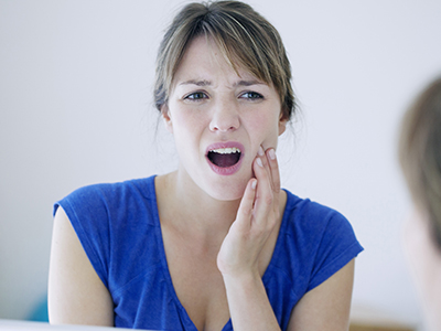 A woman with braces expressing concern about her teeth.